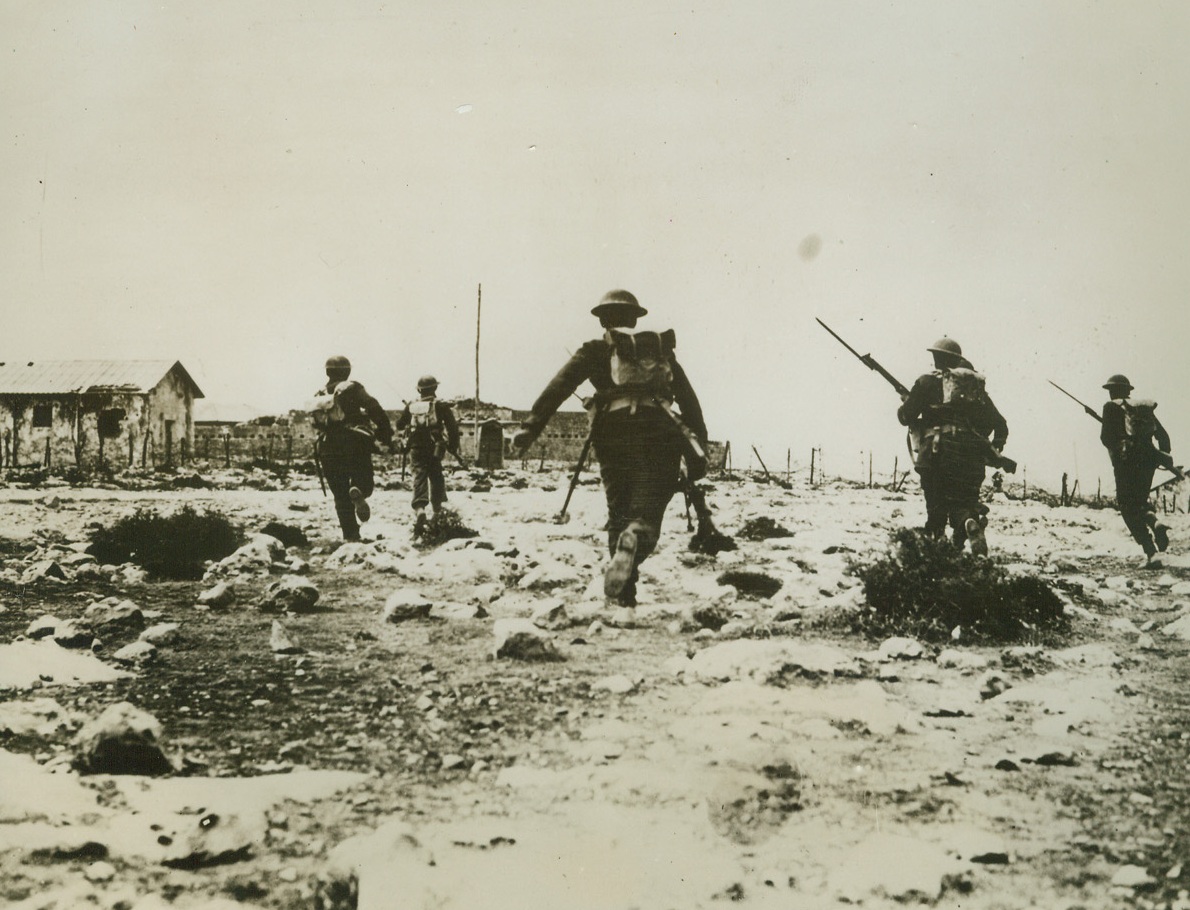 CROSSING VITAL GROUND, 3/11/41  DERNA—British infantry attack a fort at one of the key positions of Derna. Infantrymen are shown crossing the vital ground just outside the fort, on their way to capture it. Credit Line (ACME);