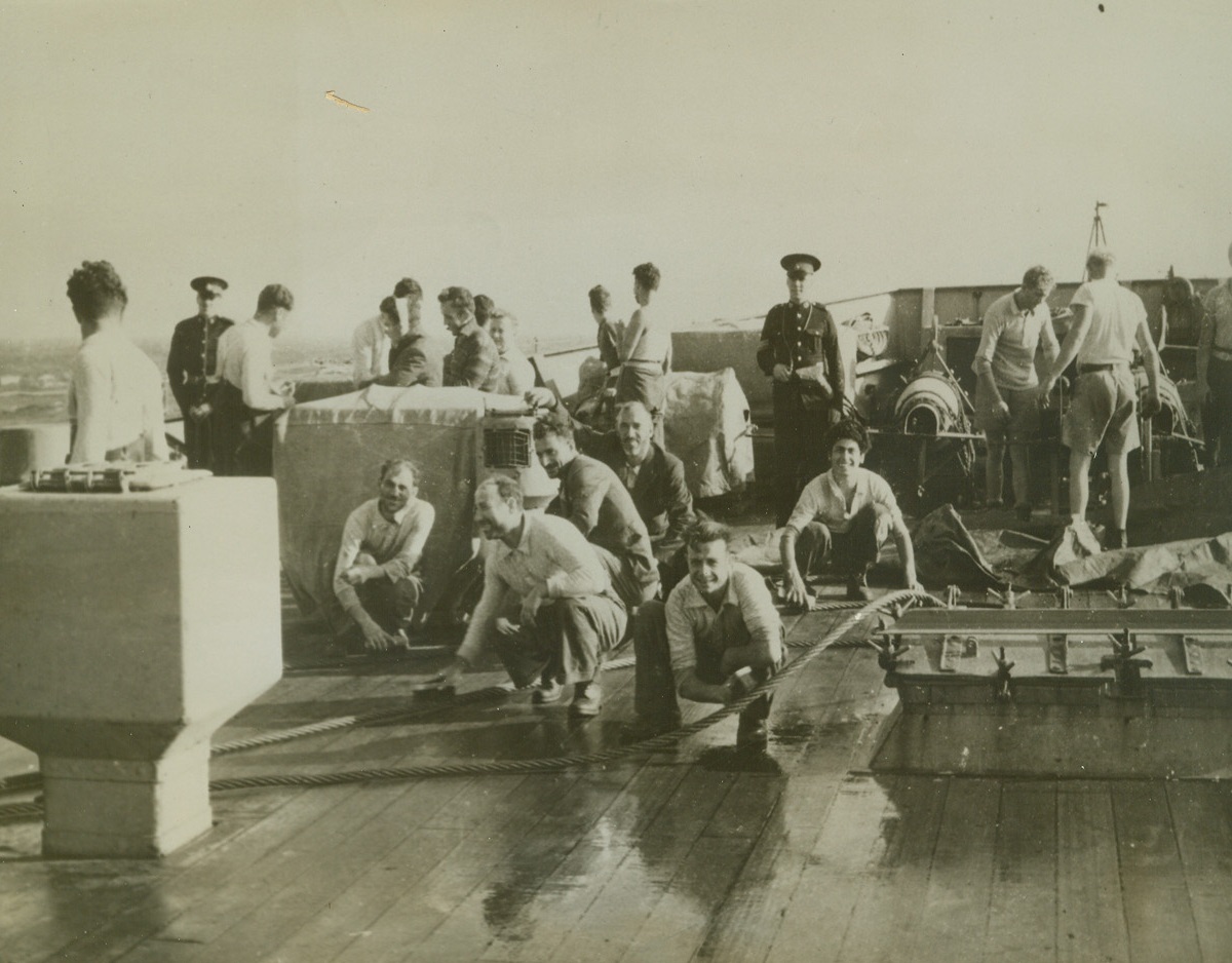 AXIS PRISONERS WORKING FOR HIS MAJESTY, 10/30/41  German and Italian prisoners captured from Axis submarines and merchant vessels are shown getting a workout on the upper deck of a British warship, scrubbing wire hawsers to earn their passage. The British-censored caption which accompanied the photo said that the prisoners look forward to this work and admitted that they do it well. Credit: Acme;