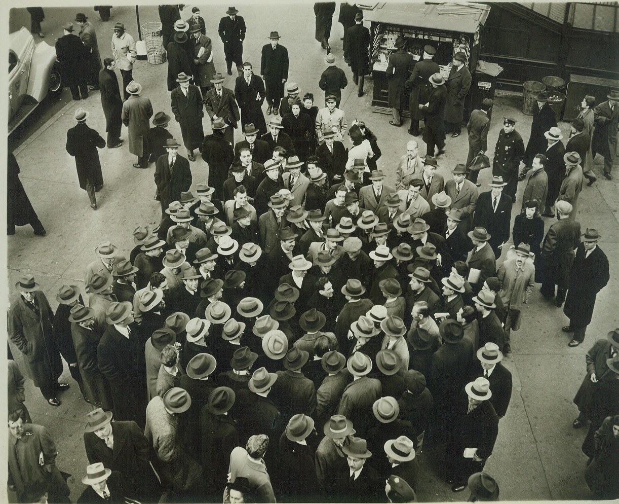 CROWDS IN TIMES SQUARE DISCUSS “AIR RAID”, 12/9/41  NEW YORK, N.Y. – Crowd gathers around air raid warden (center, without hat) to discuss first air raid warning in history of New York City, in Times Square, Dec. 9 after “phony” report of enemy planes off Atlantic Coast had sent coastal defenses into swift action. Credit: OWI Radiophoto from ACME;