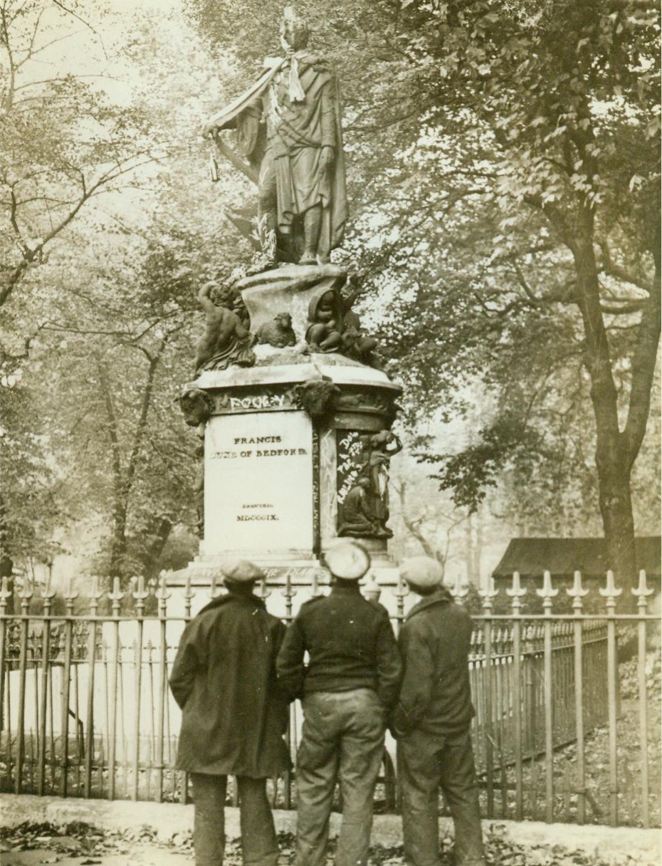 Duke of Bedford’s statue defaced, 11/3/1941. LONDON – Because the present Duke of Bedford would not allow the iron railings around the Duke of Bedford statue in Russell Square to be removed for use in Britain’s defense effort, irate citizens defaced the statue by inverting a paint-pot on the head, hanging a bottle from the wrist, placing a scarf around the neck, and scrawling uncomplimentary remarks around the base. CREDIT LINE (ACME) 11/3/41;